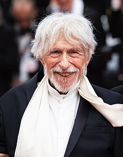 <p>Pierre Richard é um renomado ator, diretor e roteirista francês. Ele é amplamente reconhecido por seus papéis cômicos como personagens desajeitados e excêntricos, destacando-se em filmes como “O Alto, o Loiro do Sapato Preto” e “A Cabra”.</p>
<p>Seu estilo pastelão, linguagem corporal única e habilidade em interpretar anti-heróis o tornaram extremamente popular, consolidando-o como um dos grandes sucessos de bilheteria nas décadas de 1970 e 1980. Além de sua carreira como ator, Pierre Richard também dirigiu sete longas-metragens, nos quais estrelou e abordou críticas sociais através da comédia.</p>
<p>Figura icônica do cinema de comédia francês, recebeu um prêmio César honorário em 2006 e foi homenageado no Festival de Cannes em 2025. Seu sucesso também é notável no exterior, particularmente no antigo bloco soviético e na Ásia.</p>
